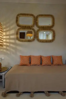 a bedroom with a bed with three mirrors on the wall at Miostello Lifestyle Riad Marrakech in Marrakech