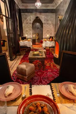 a dining room with a table with plates of food at Riad Touda in Marrakech