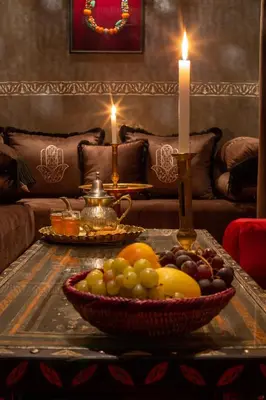 a bowl of fruit on a table with a candle at Riad Touda in Marrakech