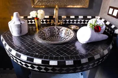 a bathroom counter with a sink and towels on it at Riad Touda in Marrakech