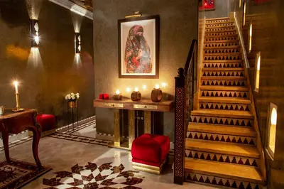 a living room with a staircase and a fireplace at Riad Touda in Marrakech