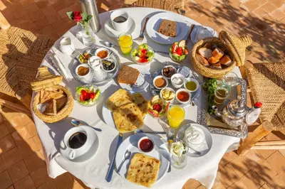 a white table with breakfast foods and drinks on it at Riad Tchaikana in Marrakech