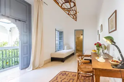 a room with a table and chairs and a bedroom at Riad Tchaikana in Marrakech