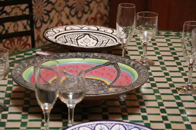 a table with a plate and glasses on a table at Riad BAB ALMADINA in Marrakech