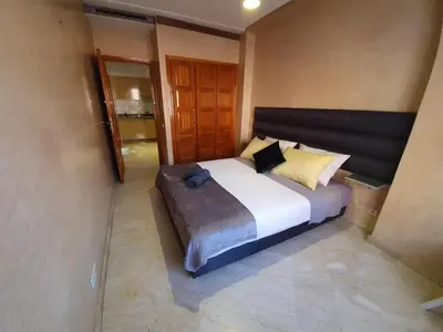a bedroom with a large white bed with yellow pillows at Charming Marrakech Apartement in Marrakech