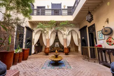 a courtyard with a fountain and potted plants at Riad Saba in Marrakech