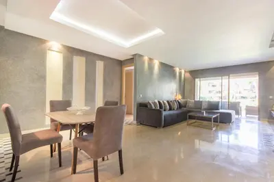 a living room with a table and a couch at Pool View With Garden in Prestigia - WIFI & Pool in Marrakech