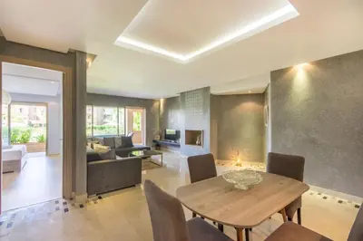 a living room with a table and a couch at Pool View With Garden in Prestigia - WIFI & Pool in Marrakech