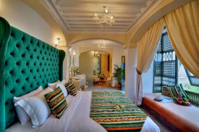 a bedroom with a large bed with a green headboard at Riad Mazarin des gourmets in Marrakech