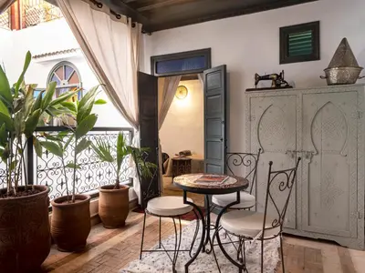 a balcony with a table and chairs and plants at Riad dar El Arsa Rooftop & jacuzzi in Marrakech