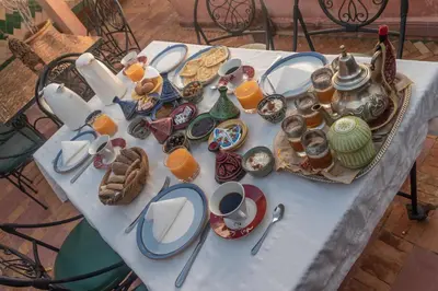 a white table with breakfast foods and drinks on it at Riad dar El Arsa Rooftop & jacuzzi in Marrakech