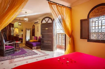 a bedroom with a red bed and a window at Riad La Kahana in Marrakech