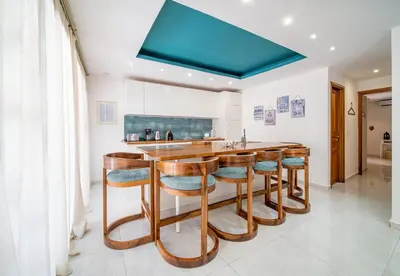 a kitchen with a bar with wooden stools at Villa White High-Standing - Breakfast in Marrakech