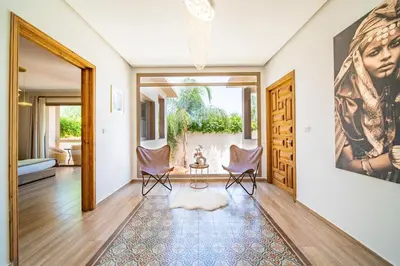 a living room with two chairs and a painting on the wall at Villa White High-Standing - Breakfast in Marrakech