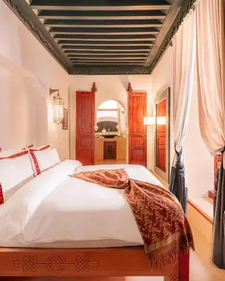 a bedroom with a large white bed and a window at Dar Assiya in Marrakech