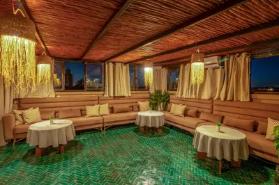 a living room with couches and tables and windows at Riad Janate & SPA in Marrakech