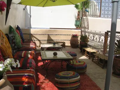 a living room with a couch and a table and an umbrella at RIAD MAKENE MOUCHKILL in Marrakech