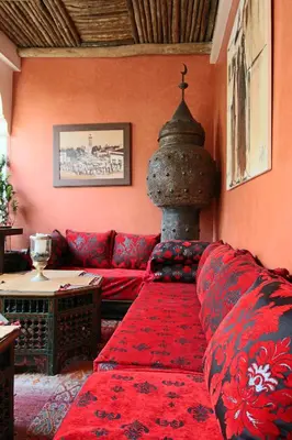 a living room with a red couch and a red rug at RIAD MAKENE MOUCHKILL in Marrakech