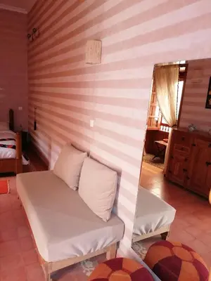 a couch in a room with a striped wall at DAR MAR'OUKA , Maison d'hôtes in Marrakech