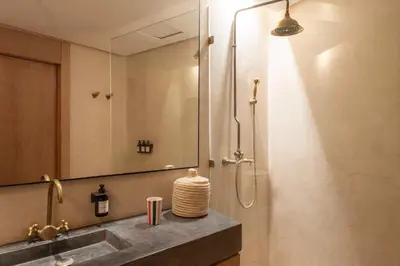 a bathroom with a shower with a sink and a mirror at Appartements Brummell Marrakech in Marrakech