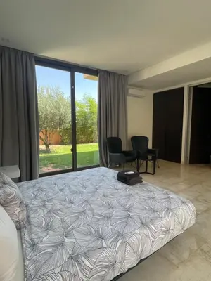 a bedroom with a large bed and a desk and chairs at Luxury Palm Villa in Marrakech
