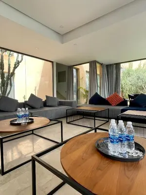 a living room with a lot of water bottles on tables at Luxury Palm Villa in Marrakech