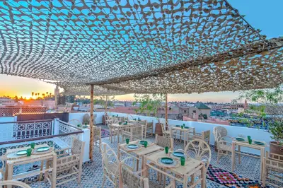 a restaurant with tables and chairs under a roof at Riad Art & Emotions in Marrakech