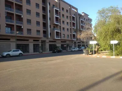 an empty street in front of a large apartment building at Opéra Appartement, Hivernage Marrakech. in Marrakech