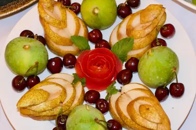 a plate of fruit with a red rose on it at La Claire Fontaine in Marrakech
