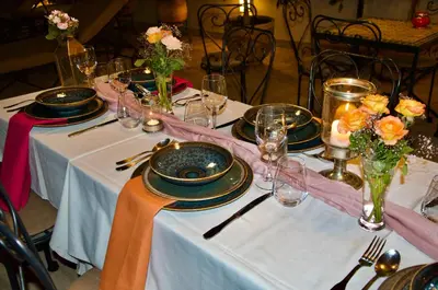 a table with plates and glasses on it with flowers at La Claire Fontaine in Marrakech
