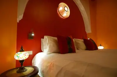 a bedroom with a bed and a clock on the wall at La Claire Fontaine in Marrakech