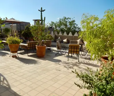 a patio with chairs and tables and plants at La Claire Fontaine in Marrakech