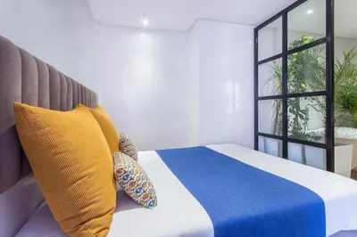 a bedroom with a bed with yellow and blue pillows at Best for group, 5 min from medina in Marrakech
