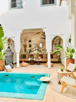 a villa with a swimming pool and a living room at Riad Baba Ali & Spa in Marrakech