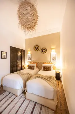three beds in a room with a chandelier at Riad Baba Ali & Spa in Marrakech