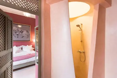a bathroom with a shower and a bed in a room at Riad Hissan in Marrakech