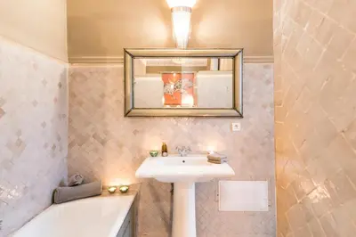 a bathroom with a sink and a mirror and a tub at Riad Hissan in Marrakech