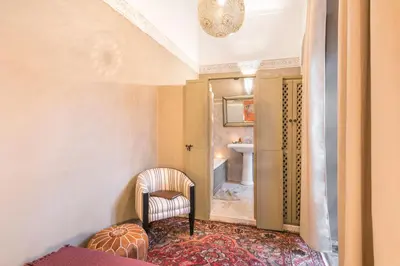 a hallway with a chair and a bathroom at Riad Hissan in Marrakech