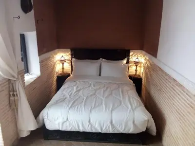 a bed in a small room with two lights at Riad Mina in Marrakech