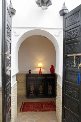 an archway in a room with a table and a lamp at Riad Mina in Marrakech