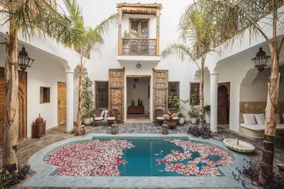 a pool in a house with palm trees around it at Riad Alkemia en exclusivité in Marrakech