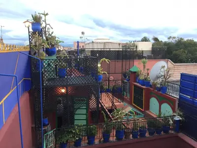 a balcony with potted plants on a building at ALMARKAB Riad in Marrakech