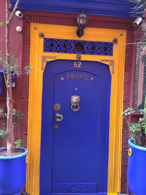 a blue front door of a house with a purple door at ALMARKAB Riad in Marrakech