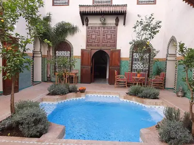 a swimming pool in the courtyard of a house at Riad Aventurine in Marrakech