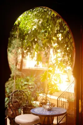 a table and chairs in front of a window at Riad Roxanne in Marrakech
