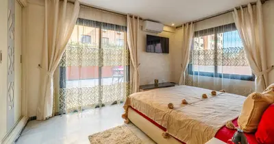 a bedroom with a bed and two large windows at AiM HOUSE in Marrakech