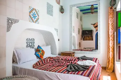 a bedroom with a bed with a large mirror at Héritage Lalla Aicha Hotel & Spa in Marrakech