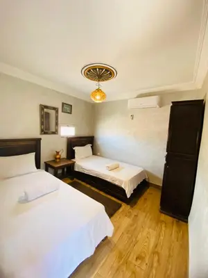 a hotel room with two beds and a chandelier at Riad Dar Essassi 23 in Marrakech