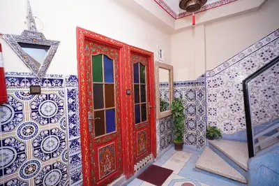 a red door in a room with blue and white tiles at Riad Dar Essassi 23 in Marrakech