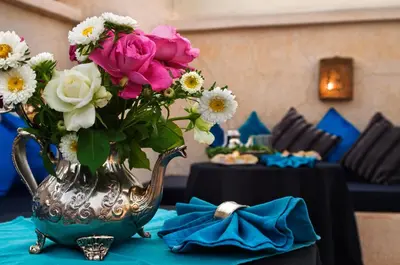 a vase filled with flowers on top of a table at Riad Papillon by Marrakech Riad in Marrakech